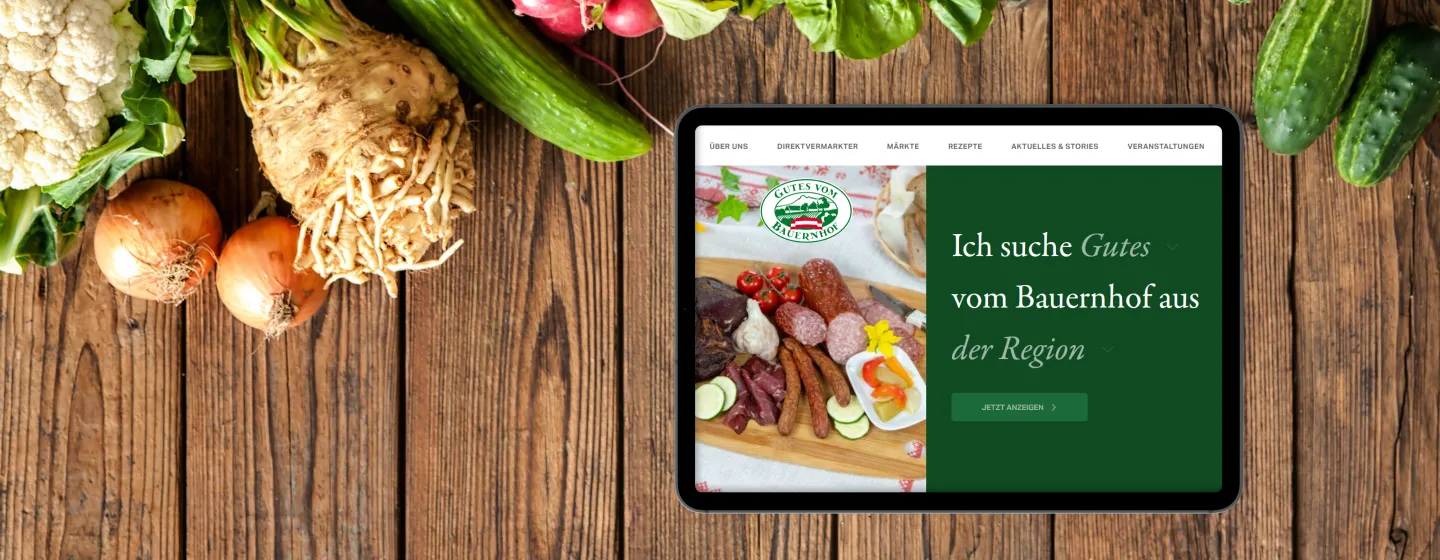 Neue GvB-Website auf Tablet, das auf einem Holztisch neben Lebensmitteln liegt