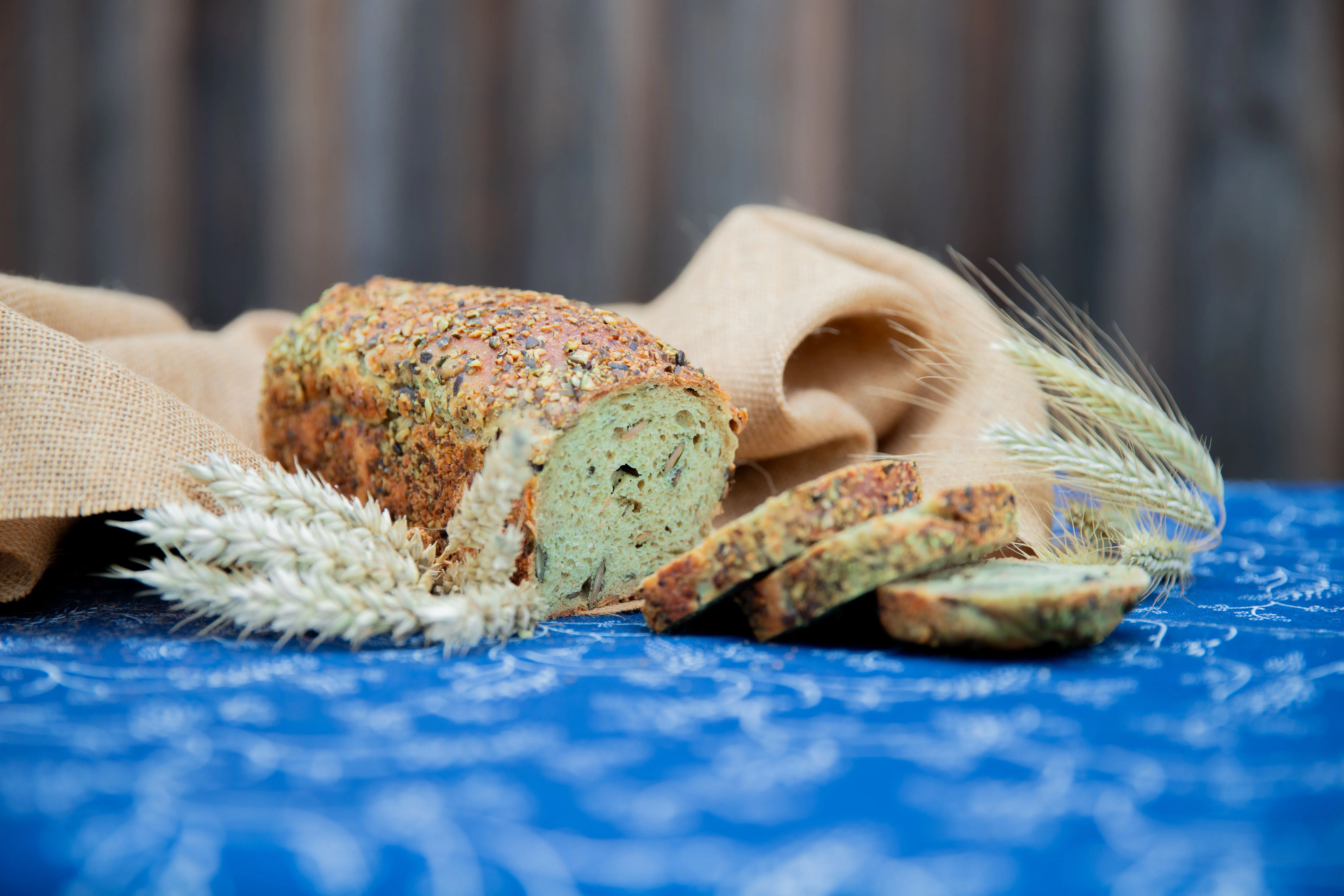 Aufgeschnittenes Brot liegt auf einer blauen Tischdecke mit brauner Wand