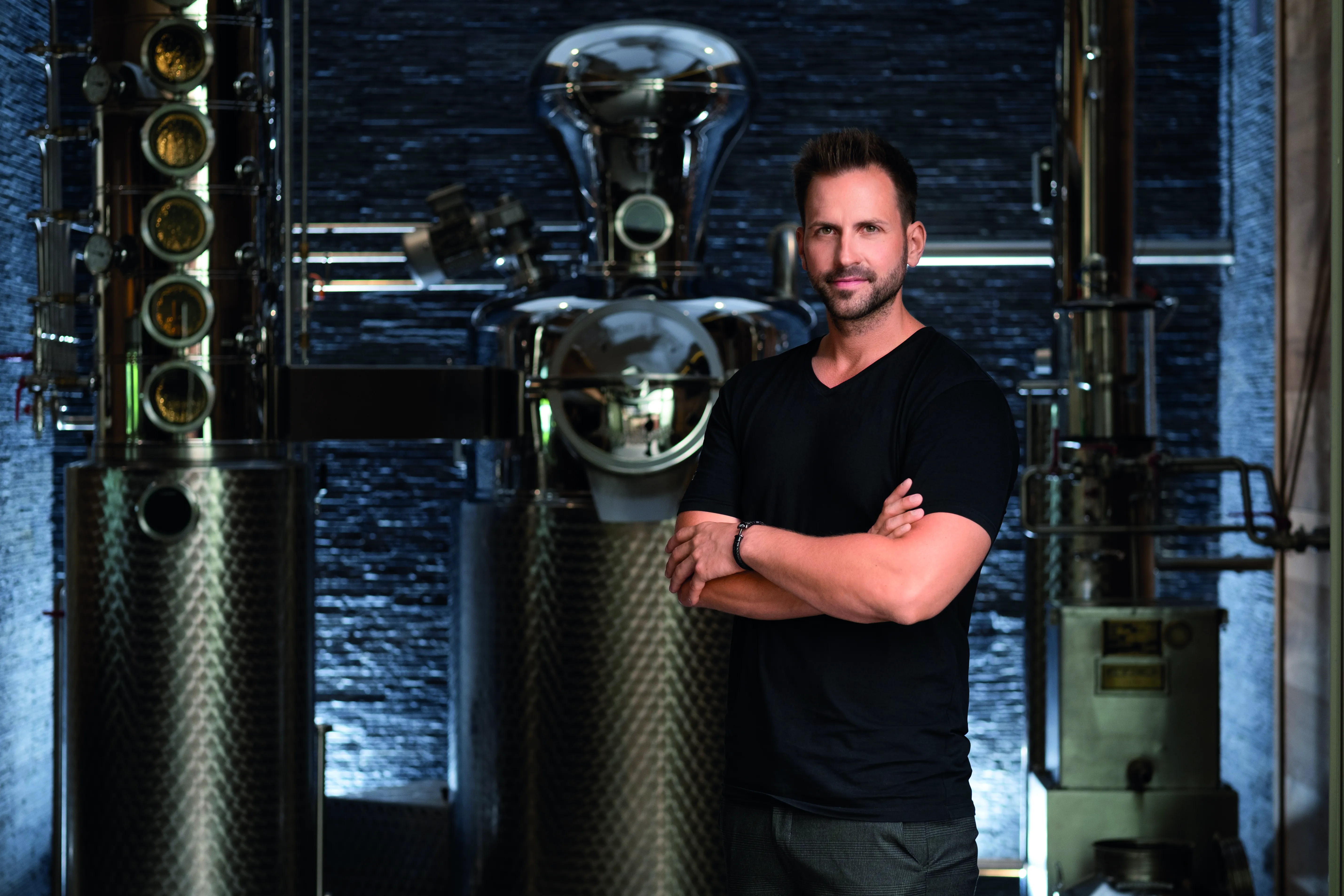 Mann steht vor den dunklen Whiskytanks