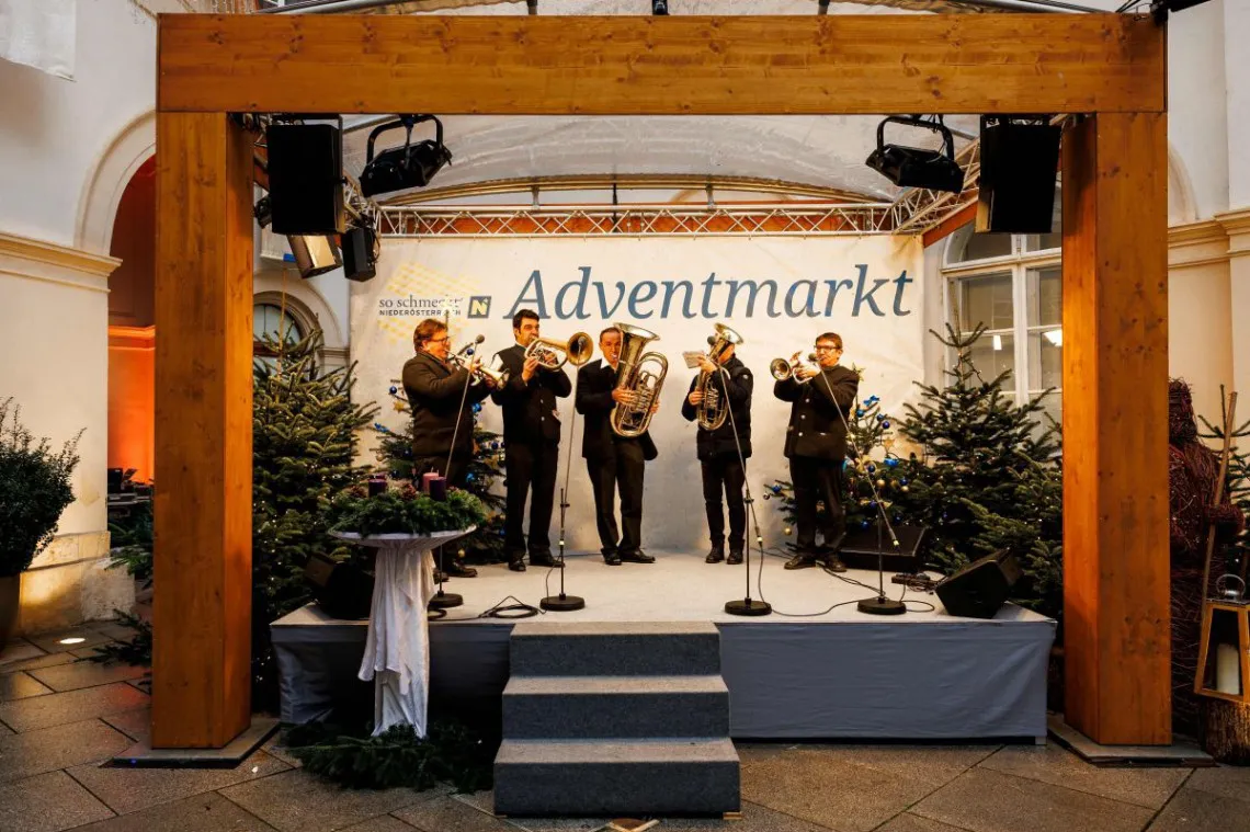 Musikanten spielen auf Bühne am Adventmarkt Palais NÖ