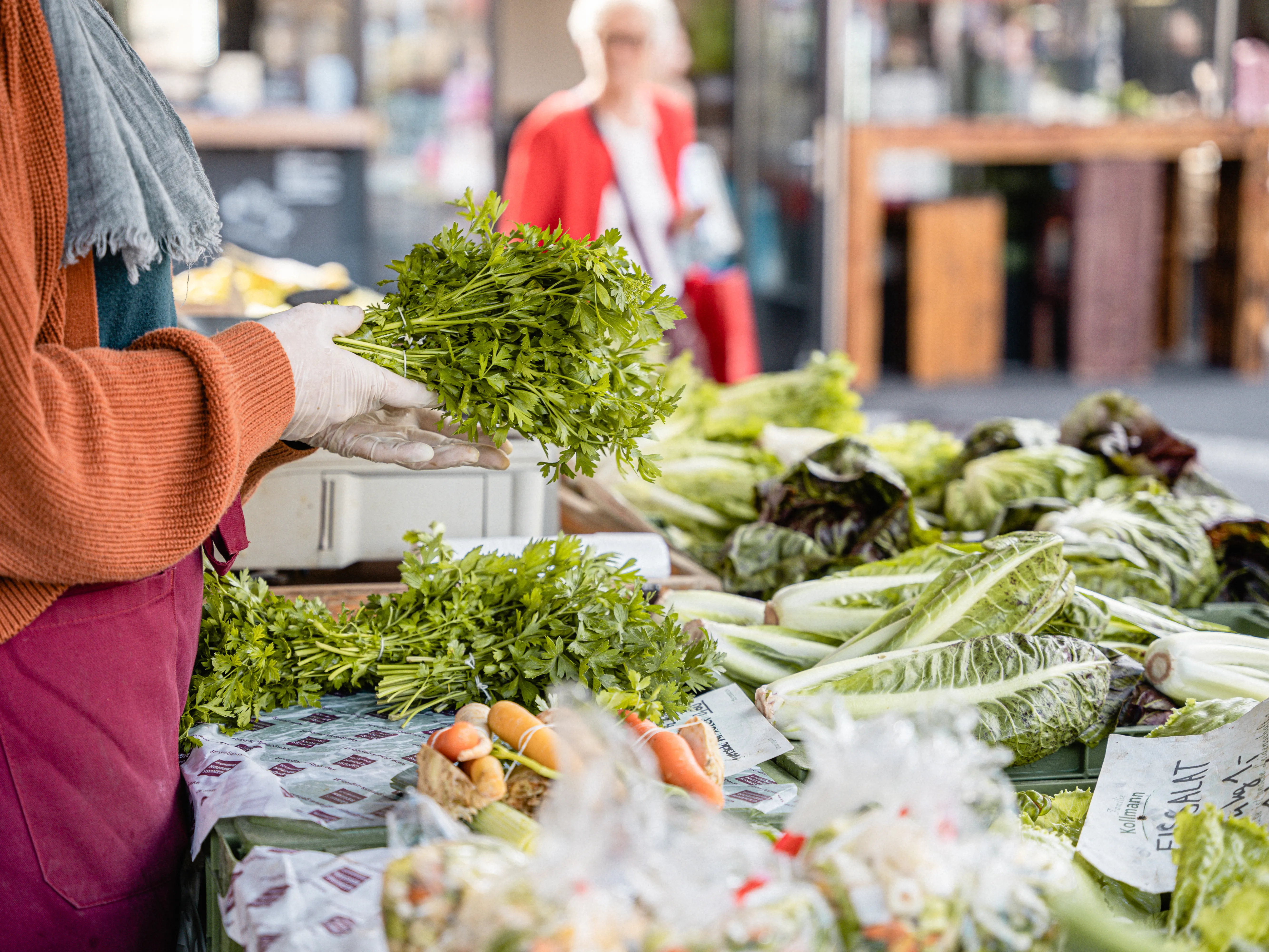 Frau verkauft Kräuter am Markt