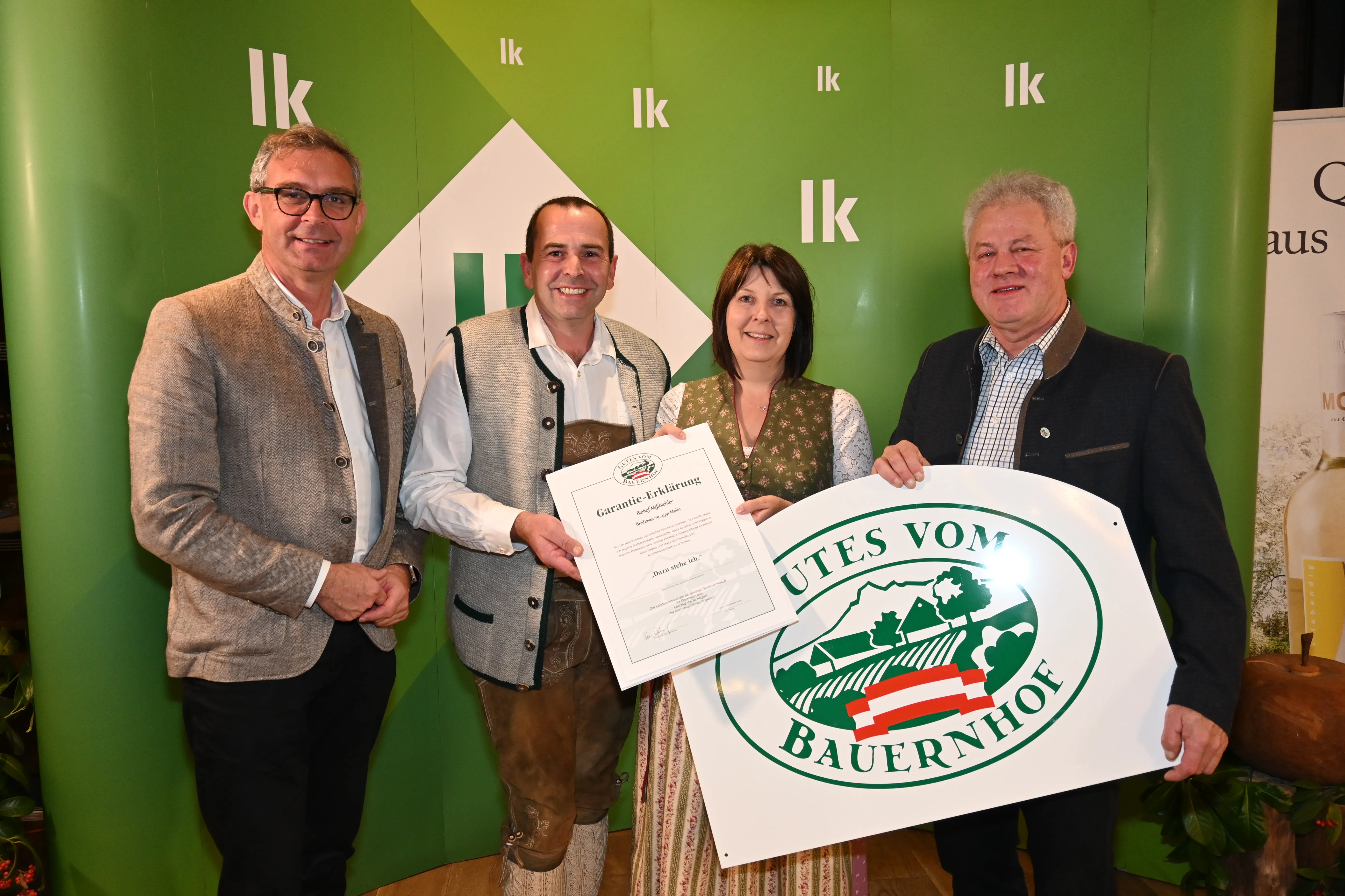 Auf dem Bild sieht man Herrn und Frau Mißbichler mit zwei weiteren Herren bei der Urkundenverleihung in der LK OÖ. Sie halten die Urkunde und die Hoftafel in die Kamera