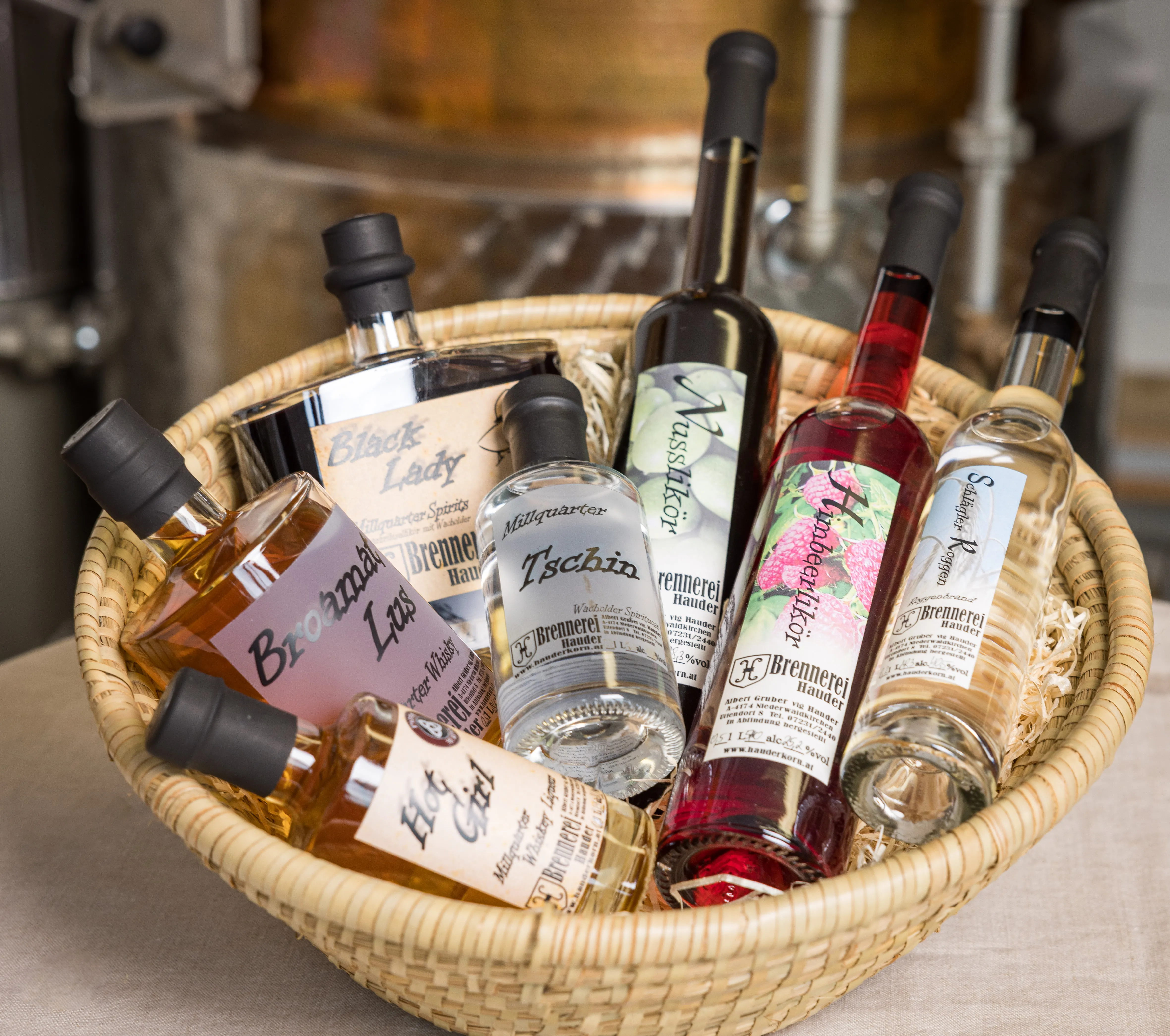In einem Korb befinden sich verschieden große Flaschen mit Spirituosen in verschiedenen Farben.