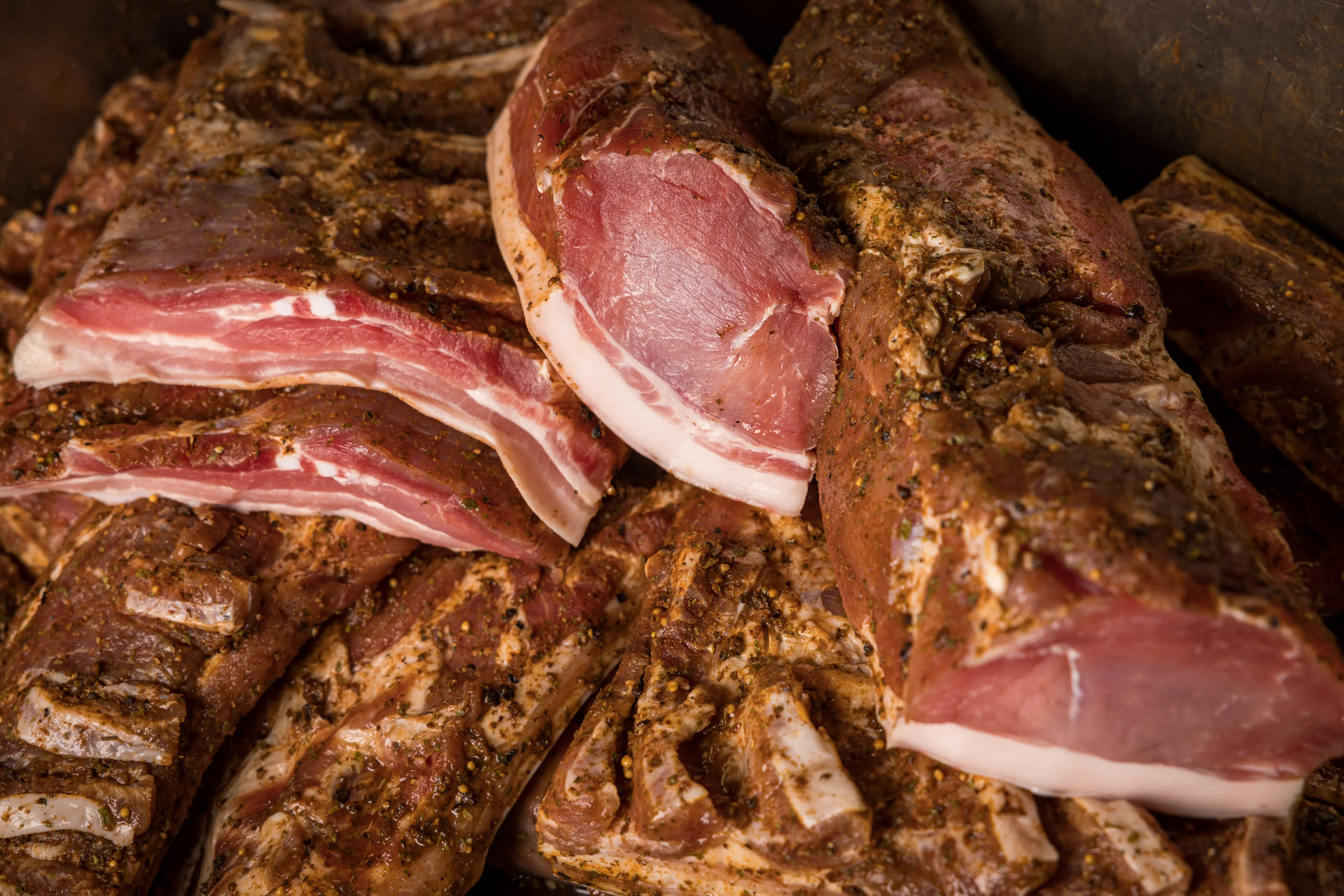 Auf einem Tisch liegen verschiedene Speckstücke aufgeschnitten
