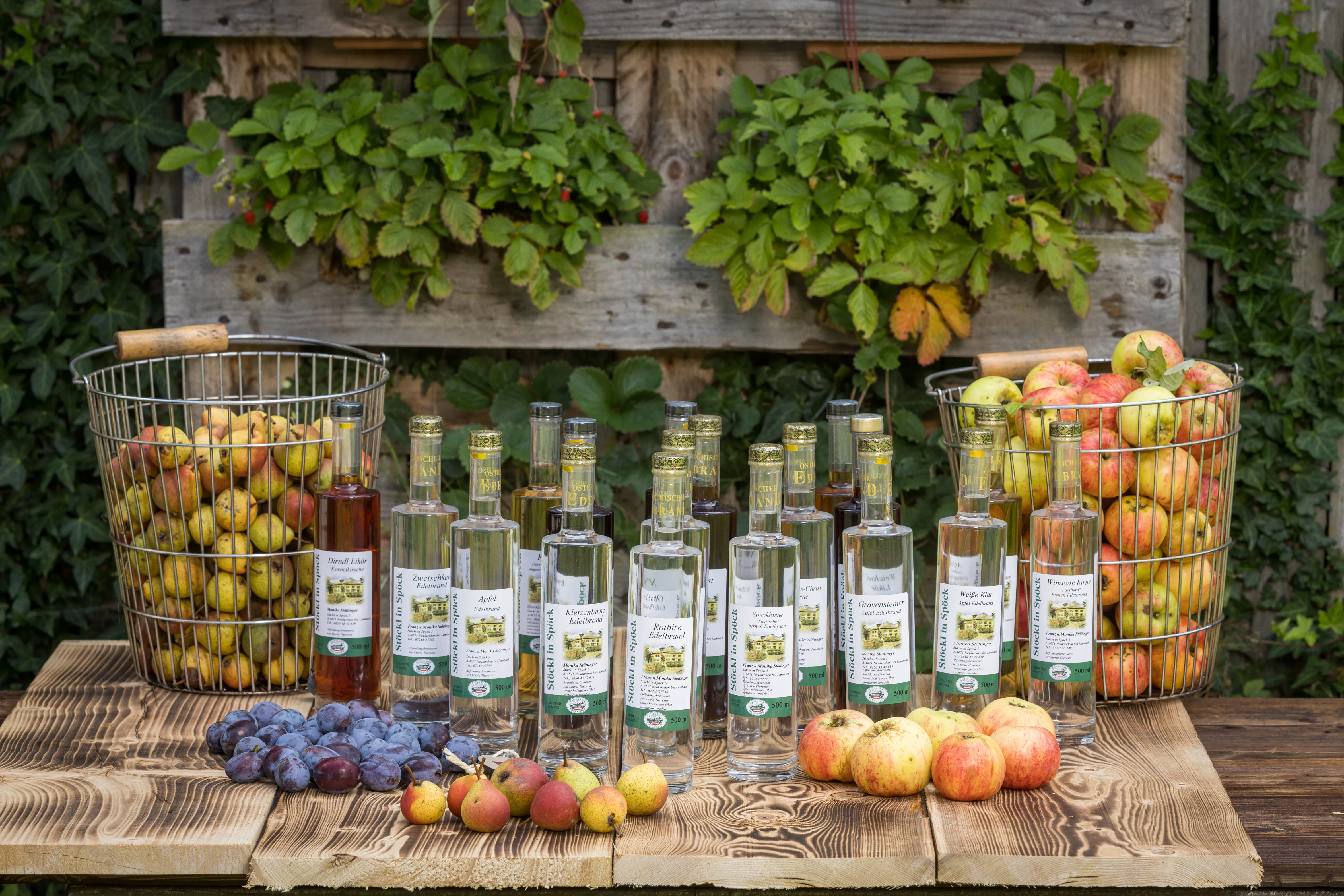 Auf einer Holzbank stehen viele Flaschen mit Spirtuosen, daneben 