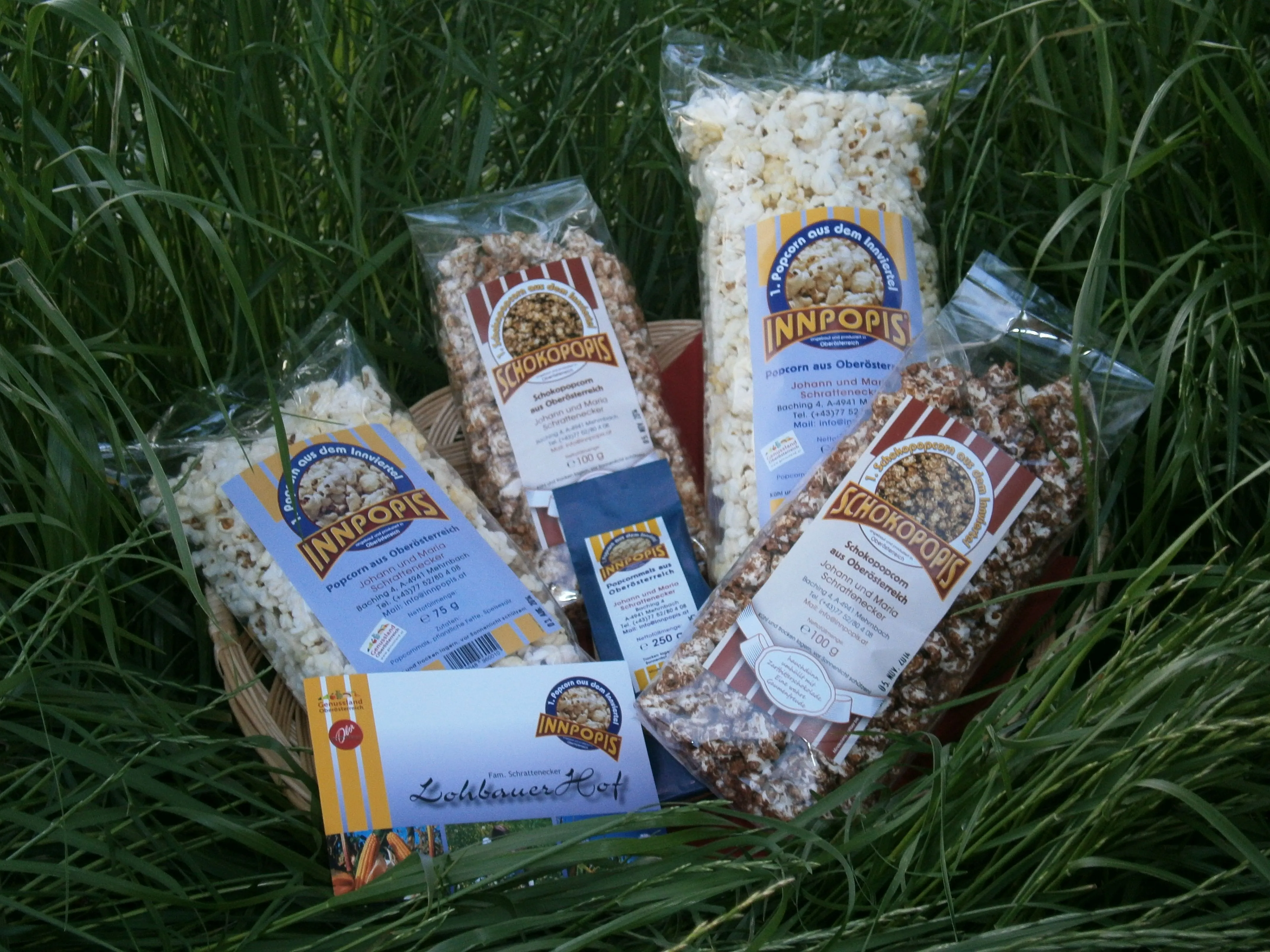 im grünen hohen Gras liegen mehrere durchsichtige Säckchen mit verschiedenem Popcorn